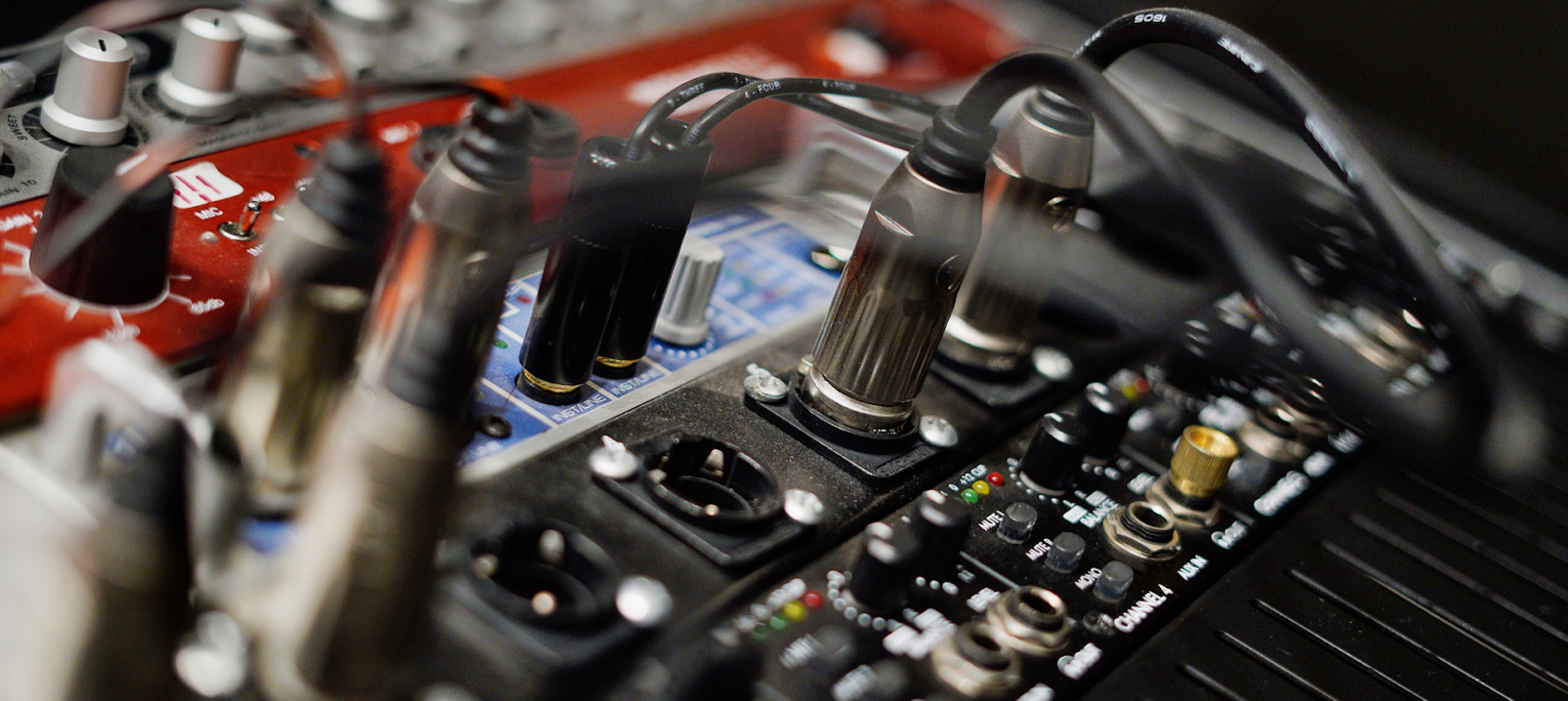 A closeup photo of an amplifier with many cables plugged into it.