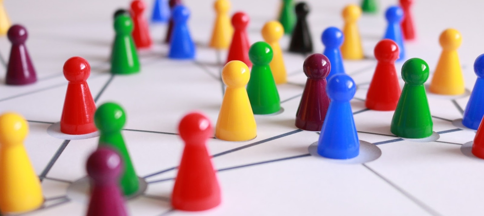 A photo of many board game meeples in different colors arranged on a board that seems to represent a network.