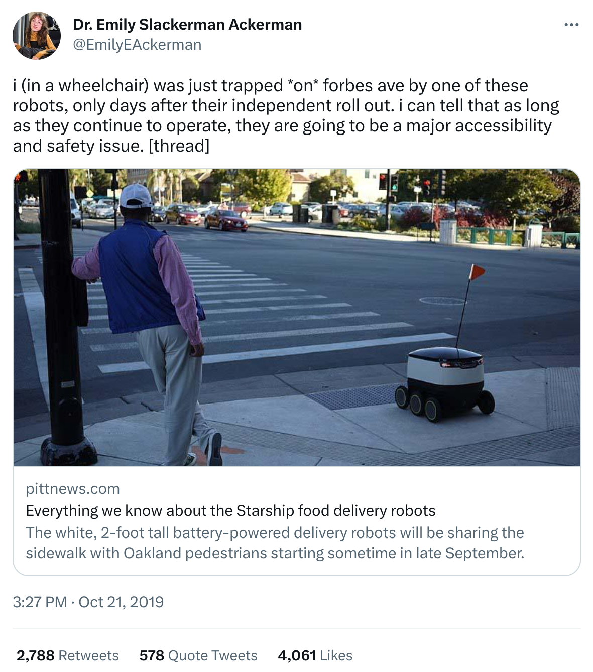 Screenshot of a twitter message reading "i (in a wheelchair) was just trapped *on* forbes ave by one of these robots, only days after their independent roll out. i can tell that as long as they continue to operate, they are going to be a major accessibility and safety issue." A photo below the text shows a small sidewalk delivery robot next to a person waiting at a crosswalk.