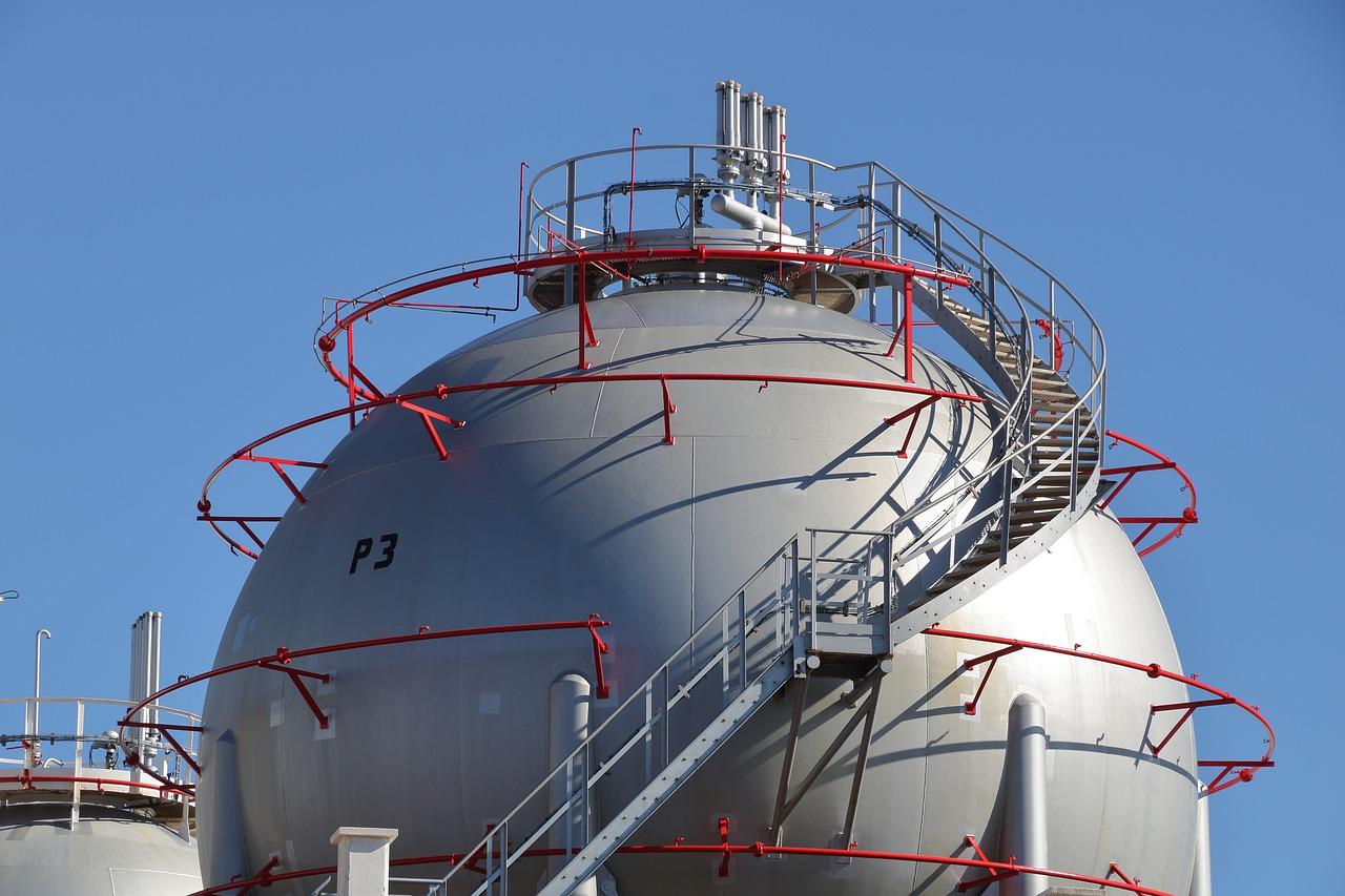 A photo of a large spherical gas storage tank in front of a blue sky.